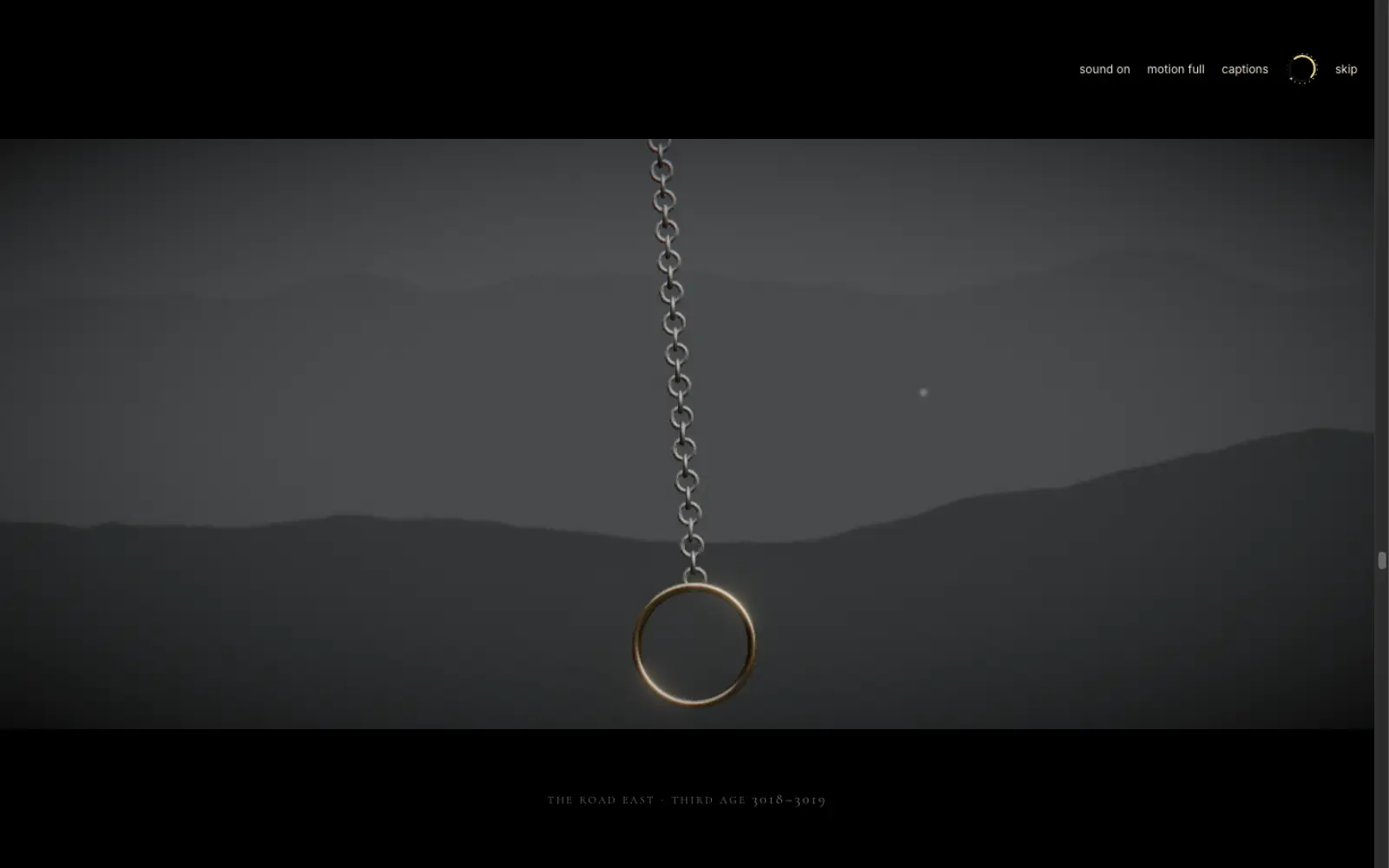 A gold ring hanging from a chain against grey layered hills, letterboxed, with a small caption reading “The road east”